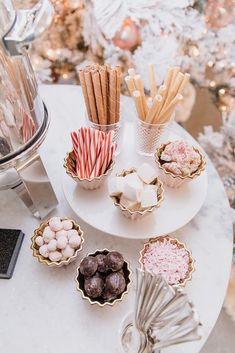 an assortment of desserts on a table in front of a christmas tree