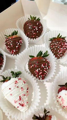 chocolate covered strawberries with sprinkles in a white box on a table