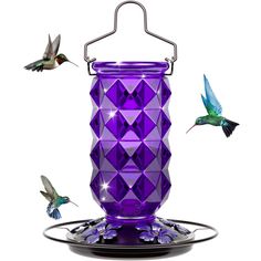 a purple bird feeder with hummingbirds flying around it