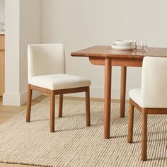 a dining room table with two chairs and a bowl on top of the table in front of it