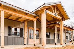 the front porch of a house with wooden pillars and columns on each side is covered in wood