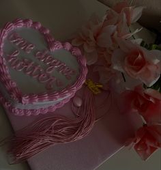 a heart shaped cake sitting on top of a table next to flowers