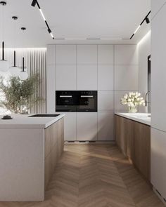 a modern kitchen with white walls and wood flooring