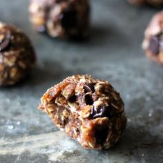 chocolate chip cookie energy bites on a baking sheet with one bite taken out and the other half eaten