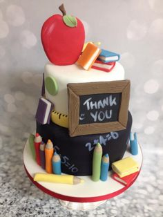 a birthday cake with an apple, pencils, and chalkboard on it