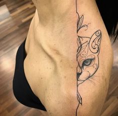 a woman's stomach with a cat tattoo on her left side ribcage