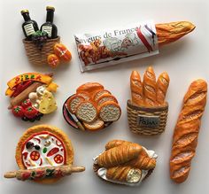 breads and pastries are arranged on a white surface