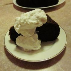 two white plates topped with chocolate cake and whipped cream