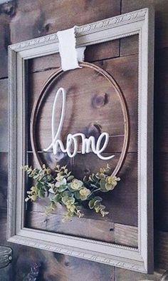 a wooden sign that says home hanging on a wall above a shelf with other items