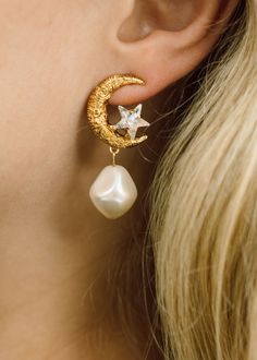 The Lune Earrings feature a gold moon with carefully carved detail. These earrings celebrate the inspiration of the moon as a symbol of femininity, wisdom, and spiritual connection. A tiny crystal star is nestled in the crook of the moon, and a baroque-style pearl adds a feminine touch. Explore more styles from The Celestial Edit. Luxury Hair Accessories, The Bling Ring, Jennifer Behr, Celestial Jewelry, Gold Moon, Crystal Stars, Spiritual Connection, Discount Sale, Pearl Earrings Dangle