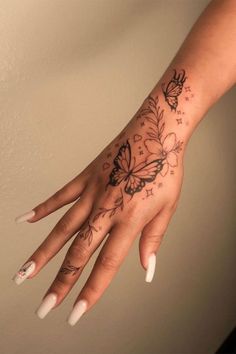 a woman's hand with a butterfly tattoo on the middle of her left arm