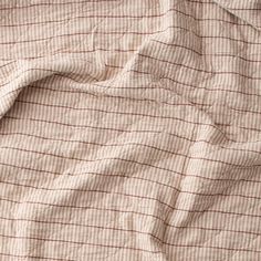 an unmade bed with a brown and white checkered comforter