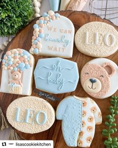 decorated cookies are arranged on a wooden platter