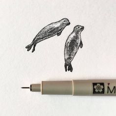 an ink drawing of two penguins on white paper next to a marker with the word mom written in it