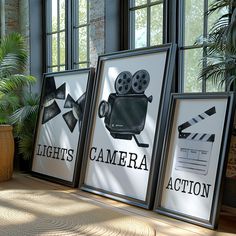 three framed movies sitting on top of a wooden table next to a potted plant