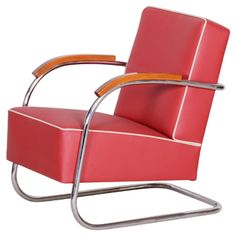 a red chair with a wooden arm rests on a metal frame against a white background