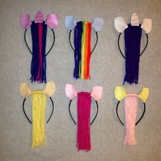 four pairs of cat ears, one with long hair and the other with multicolored yarn