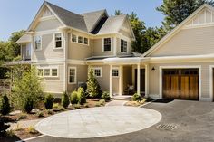 a large house with two garages on each side and an attached driveway in front