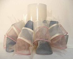 three rolls of toilet paper wrapped in mesh and tied with pink ribbon on white background