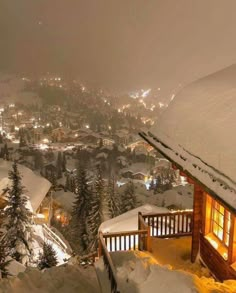 a cabin with snow on the roof and lights in the windows