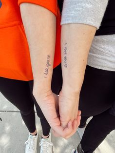 two people holding hands with tattoos on their arms that say, i love you and always