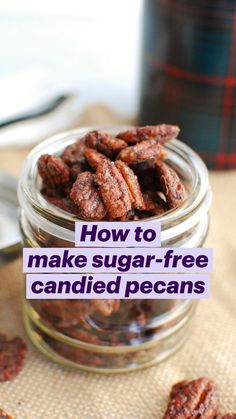 a glass jar filled with pecans sitting on top of a table next to a can