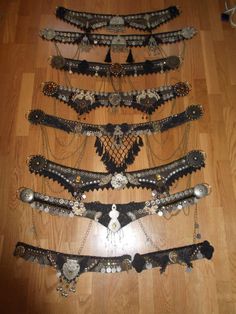 several different types of bracelets are arranged on the floor in a row, all with chains attached to them