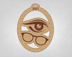 a wooden ornament with an eye and glasses in the shape of a circle