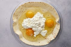 three eggs and cream in a bowl on a counter top, with other ingredients to make an appetizer