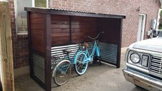 a blue bike parked in front of a wooden shed