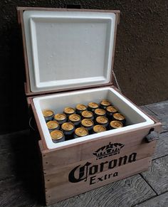 a wooden box filled with bottles of corona beer sitting on top of a brick floor