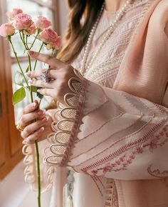 a woman is holding roses in her hand