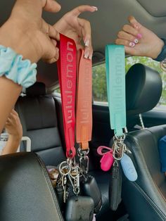 two women holding keys in the back seat of a car