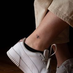 a person with a small tattoo on their ankle