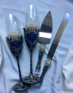 an assortment of fancy blue and gold items on a white table cloth with a knife