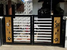 a black and yellow gate with flowers on it