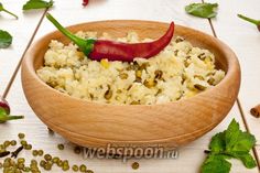 a wooden bowl filled with rice and a red hot pepper on top of green beans