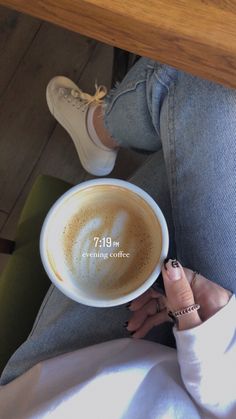 a woman holding a cup of coffee on her lap