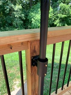 a black pipe is attached to the wooden railing