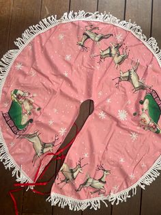 a pink table cloth with reindeers on it and a wooden spoon in the center