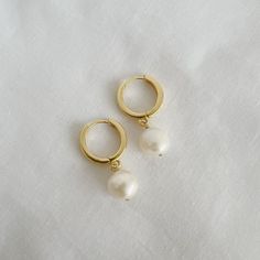 14k gold filled huggie style hoops and natural freshwater pearls. Perfect for day to night and everything in between. Lightweight. Size: 1“ Gold filled hoops Click-in closure Each natural pearl is unique and therefore no two are alike. Pearls, colors and sizes may vary Handmade Lead & nickel free Hypoallergenic Includes 100% organic cotton jewelry pouch This item is handmade and shipped with love from our studio located in West Chester, PA. *Click here to learn more about gold filled jewelry Everyday Hoop Earrings With Pearl Charm, Pearl Charm Huggie Earrings, Everyday Small Hoop Huggie Earrings With Pearl Drop, 14k Gold-filled Huggie Hoop Earrings With Pearl Charm, Small Hoop Huggie Earrings With Pearl Drop, Everyday Small Huggie Earrings With Pearl Drop, Minimalist 14k Gold Filled Huggie Earrings With Pearl Charm, Hypoallergenic Pearl Huggie Earrings, Everyday Pearl Drop Huggie Earrings