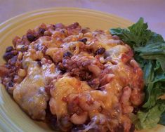 a yellow plate topped with lasagna and lettuce