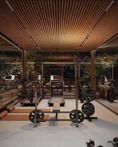 an indoor gym with rows of exercise equipment and lights on the ceiling, in front of large windows