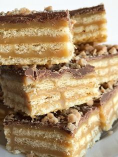 several pieces of cake sitting on top of a white plate covered in chocolate and nuts