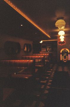 a dimly lit restaurant with booths and tables