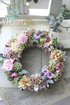 a wreath made out of flowers sitting on top of an open book