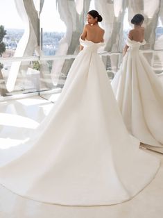 two women in wedding dresses looking at each other