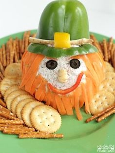 a green plate topped with crackers and a face