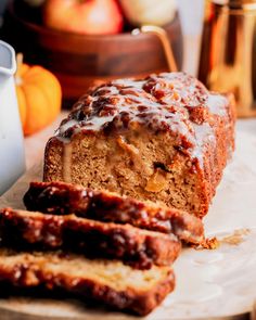 there is a loaf of bread with chocolate glaze on it and some oranges in the background