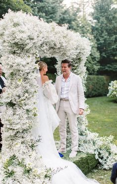 a bride and groom walking down the aisle at their wedding ceremony in an outdoor garden